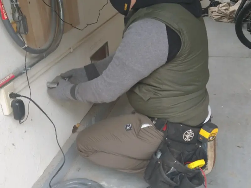 Electrician performing outlet wiring in a Camano garage